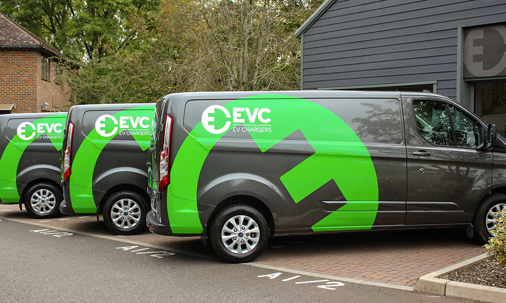 A fleet of EVC vans parked outside the head office.