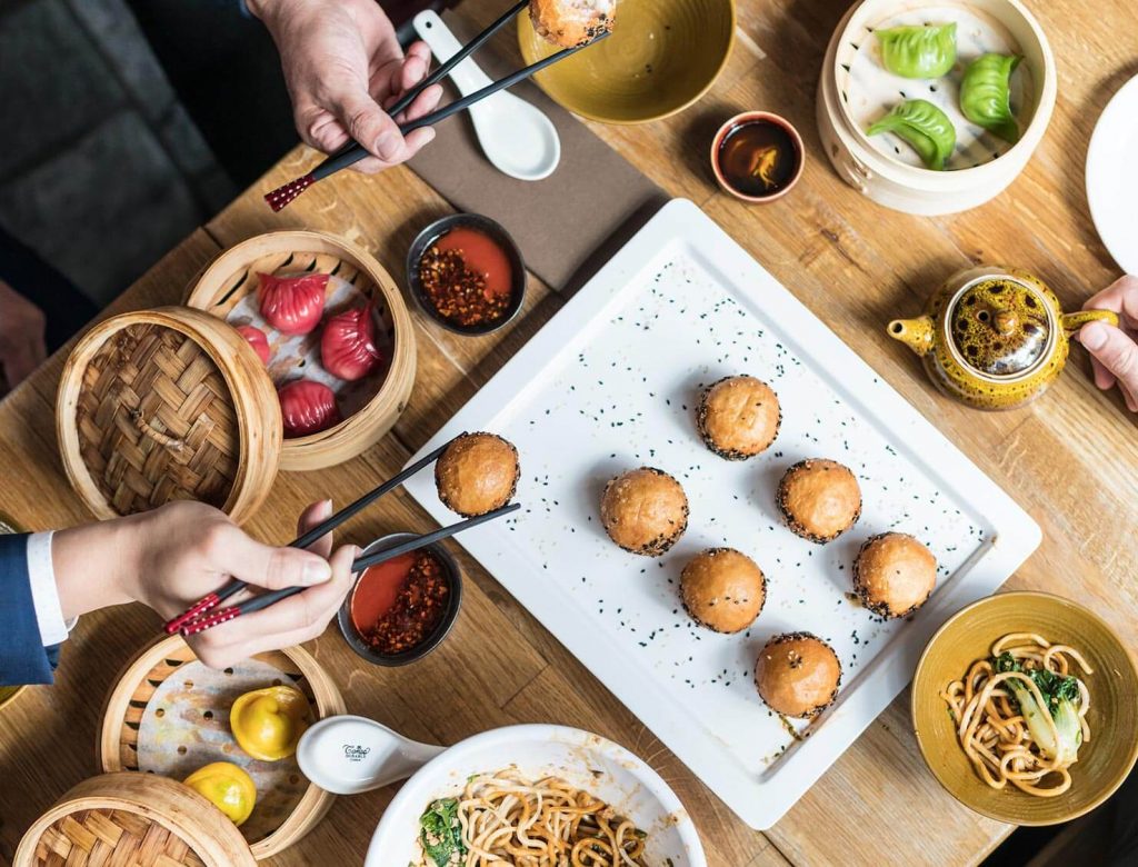 Aerial photograph of a dining table with people sharing food.